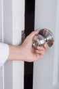 Hand opening door knob on white door Royalty Free Stock Photo