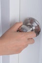 Hand opening door knob on white door Royalty Free Stock Photo