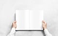 Hand opening white journal with blank pages mockup. Royalty Free Stock Photo