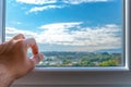 Hand opening window to scenic landscape and cloudy blue sky view Royalty Free Stock Photo