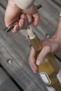 Hand opening a wine bottle with a corkscrew Royalty Free Stock Photo