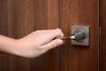 A hand opens the door, holding the doorknob