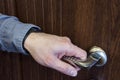 A hand opens the front door. Holding the door handle