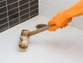 Hand in orange glove cleaning bathroom dirty floor Royalty Free Stock Photo