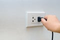Hand outlet Power saving Hand inserting electrical plug into outlet