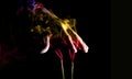 Hand over coloured smoke coming out of incense sticks. Abstract smoke art