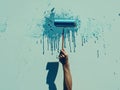 The hand of a paint roller drips blue paint onto a white wall Royalty Free Stock Photo