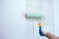 Hand with a paint roller priming the wall before painting Royalty Free Stock Photo