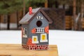 A Hand-painted Bright Birdhouse Close-up Stands On A Wooden Table Outdoors In Winter. Taking Care Of Birds, Nature