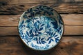 Hand-painted ceramic plate with floral design on wooden background