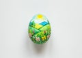 Hand-painted Easter egg with vibrant landscape and sunlit meadow scene Royalty Free Stock Photo