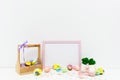 Hand painted Easter eggs in trendy colors in basket with pink Easter bunny. Photo frame mockup, copy space for text.