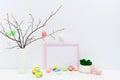 Hand painted Easter eggs in trendy colors with pink Easter bunny, twigs. Blank photo frame mockup, copy space for text.
