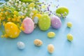 Hand painted multicolored decorated eggs on straw, blue wood.