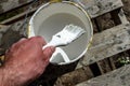 Hand painter with a brush and a jar of white paint is preparing to paint the house, wall