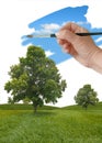 Hand painting blue sky over green landscape, environment sustainability concept