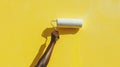 Hand painting a yellow wall with a paint roller Royalty Free Stock Photo