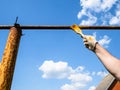 Hand paints rusty outdoor gas pipeline in village