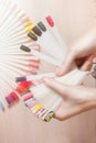 Top view woman choose manicure colorful nail polish. Nail technician shows the color palette of nail services in beauty salon stor