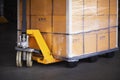 Hand Pallet Truck with Packaging Boxes Wrapped Plastic Stacked on Pallets. Hand Lift, Pallet Jack Loader Cartons, Cardboard Boxes. Royalty Free Stock Photo