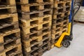 Hand pallet truck with stack of wooden pallets. Warehouse equipment. Transportation of goods in stock.Lifting equipment Royalty Free Stock Photo