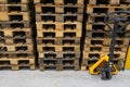 Hand pallet truck with stack of wooden pallets. Warehouse equipment. Transportation of goods in stock.Lifting equipment Royalty Free Stock Photo