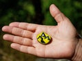 Hand palm holding chakra stone in heart shape with paint of mountains outline