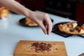 The hand of pastry chef with grated chocolate. Going to sprinkle the cake