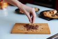 The hand of pastry chef with grated chocolate. Going to sprinkle the cake