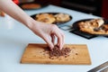 The hand of pastry chef with grated chocolate. Going to sprinkle the cake