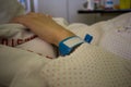 Hand of a patient in a hospital robe wearing a blue patient identification bracelet Royalty Free Stock Photo