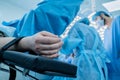 Hand of a patient lying on the operating table. The patient is sleeping under general anesthesia