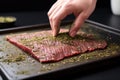 hand patting dry herb rub on beef steak