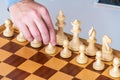 Hand with pawn makes first move on chess Board Royalty Free Stock Photo