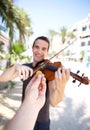 Hand paying money to busker man playing violin Royalty Free Stock Photo