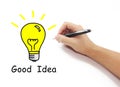 Hand with pen drawing big yellow light bulb with Good idea word Royalty Free Stock Photo