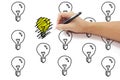 Hand with pen drawing scribbles on yellow light bulb idea among Royalty Free Stock Photo