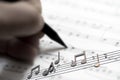 Hand With Pen And Music Sheet - Musical Background Royalty Free Stock Photo