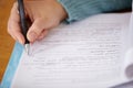 Hand, pen and teacher mark paper, education and learning with closeup of test or assignment on desk in classroom. Person