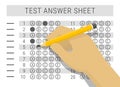 Hand with pencil filling out answers on exam test answer sheet Royalty Free Stock Photo