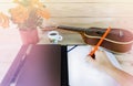 Hand with pencil, writing down on blank paper note with ukulele Royalty Free Stock Photo