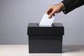 Hand of a person casting a vote into the ballot box during elections. Royalty Free Stock Photo