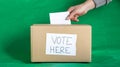 Hand of a person casting a vote into the ballot box during elections. chroma background Royalty Free Stock Photo