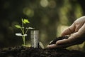 Hand of person holding soil and with coins,plant on nature background