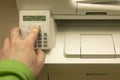 Hand of a person presses the buttons on the control panel of a printer