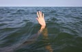 hand of the person about to drown in the middle of the sea after shipwreck