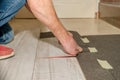 Hand of a person working that has several fingers amputated. Person with dirty clothes laying a floor in his house. Physical disab