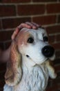 Hand petting a dog sculpture