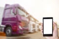 Hand with a phone on the background of parking with trucks. The concept of the application for truckers on the phone to search for Royalty Free Stock Photo