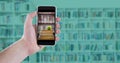 Hand with phone showing book pile with apple against blurry bookshelf with blue overlay